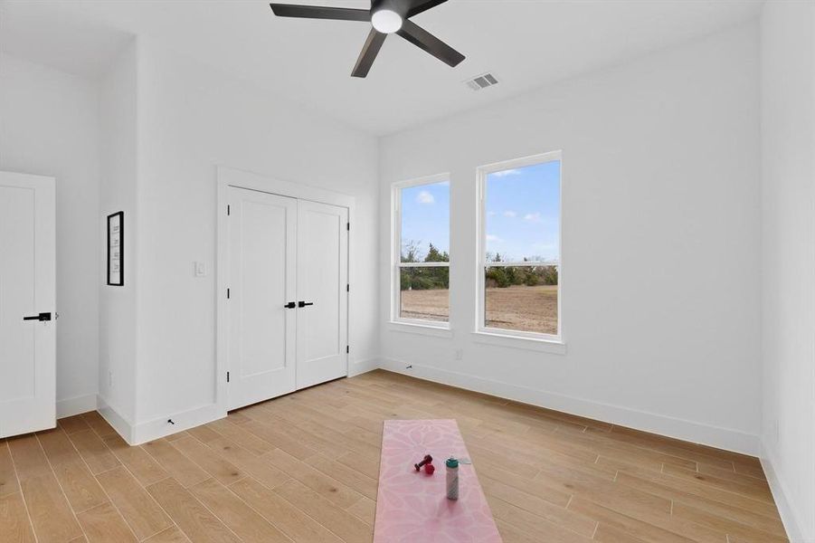 Unfurnished bedroom featuring wood finish floors, ceiling fan, and a closet