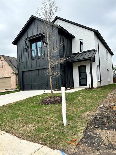 Modern inspired farmhouse with a front lawn and a garage