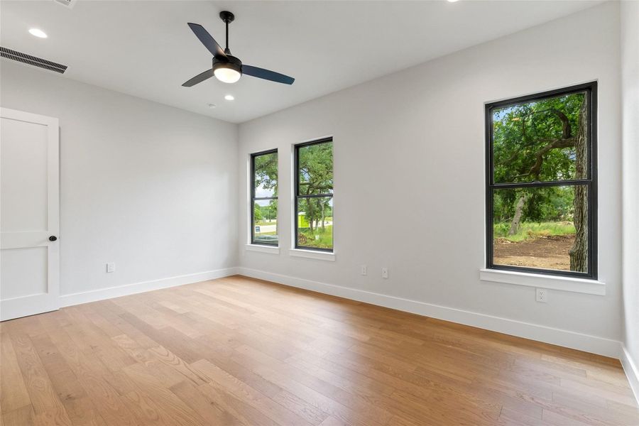 Wood flooring and modern windows complement this sun-filled, spacious room.