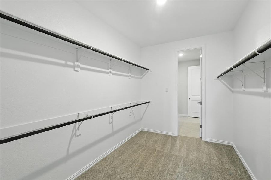 Walk in closet featuring light colored carpet Walk in closet featuring light colored carpet
