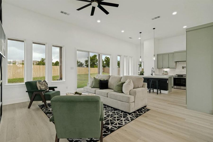 Open-concept living space featuring wood-finish flooring, recessed lighting, and a ceiling fan Open-concept living space featuring wood-finish flooring, recessed lighting, and a ceiling fan