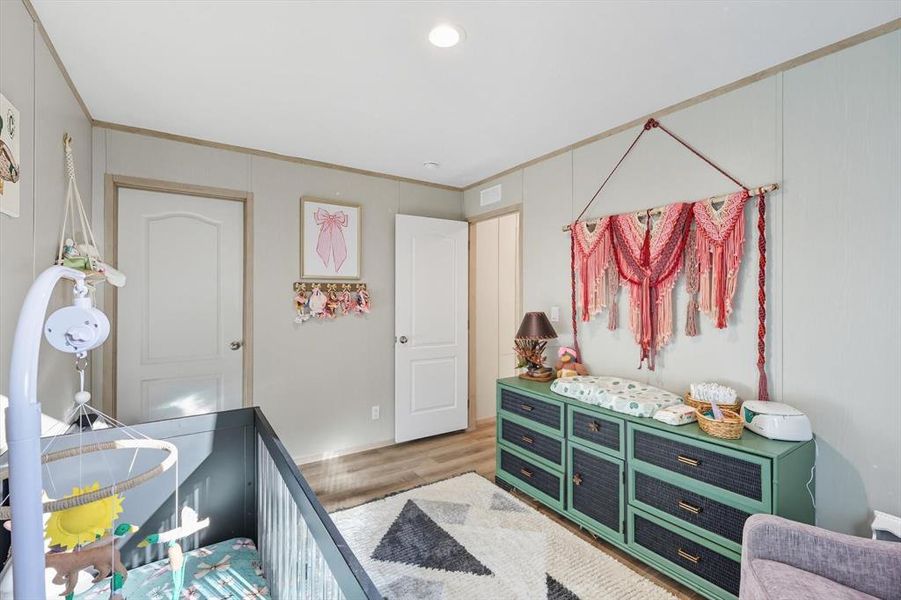 Bedroom featuring wood finished floors, recessed lighting, a closet, and ornamental molding Bedroom featuring wood finished floors, recessed lighting, a closet, and ornamental molding