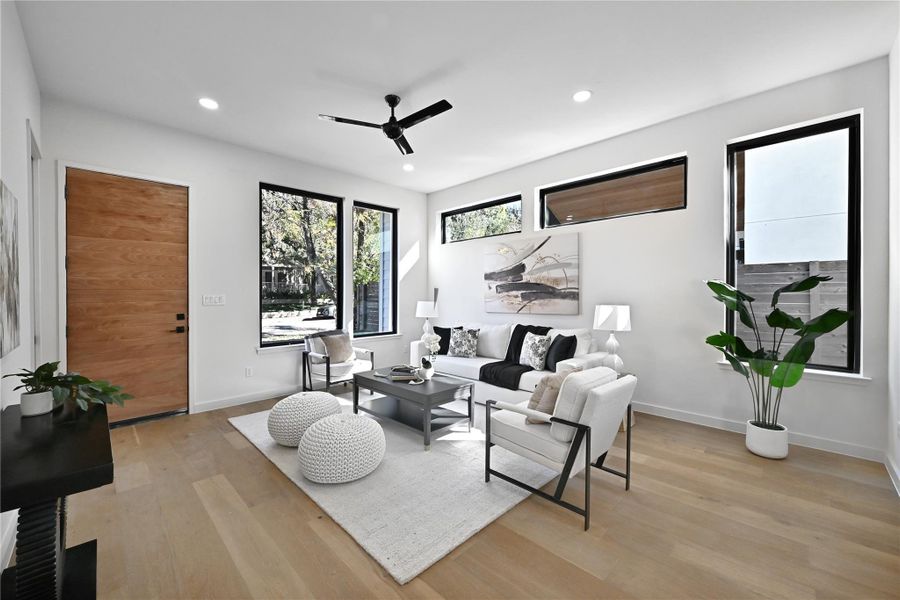 Living area featuring light wood-type flooring, ceiling fan, and recessed lighting