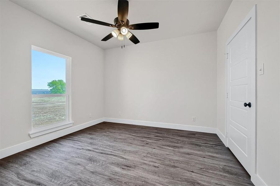 Unfurnished room featuring ceiling fan and dark hardwood / wood-style floors