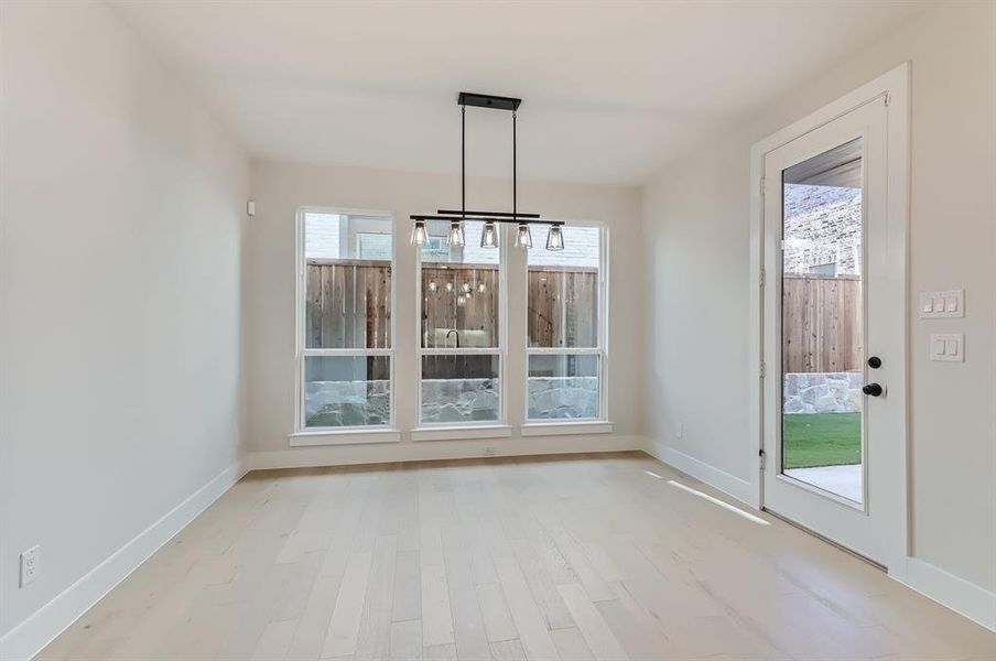 Unfurnished dining area featuring light hardwood / wood-style flooring and a chandelier