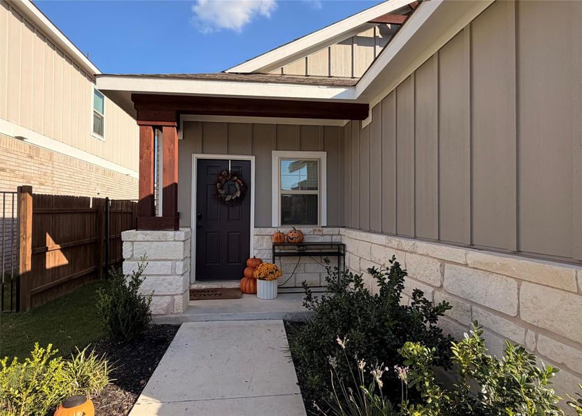 Doorway to property featuring board and batten siding and covered porch Doorway to property featuring board and batten siding and covered porch