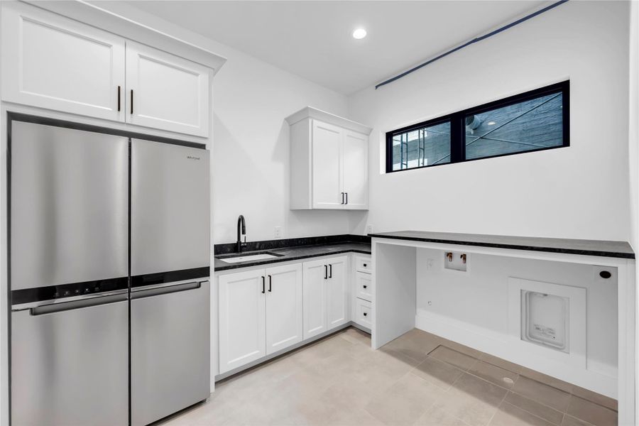 Laundry room featuring recessed lighting, light tile patterned floors, and cabinet space