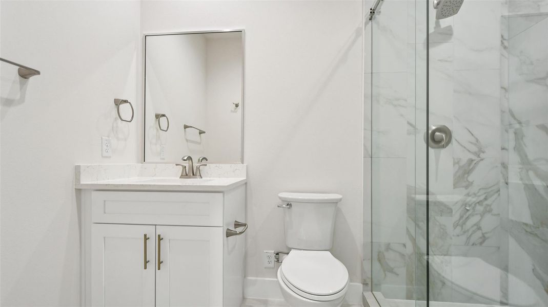 Full bath featuring a marble finish shower and vanity Full bath featuring a marble finish shower and vanity