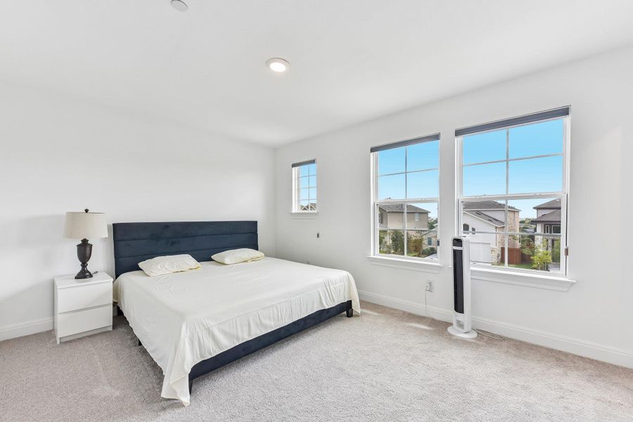 A quiet retreat, this bedroom offers bright windows and plush carpeting.