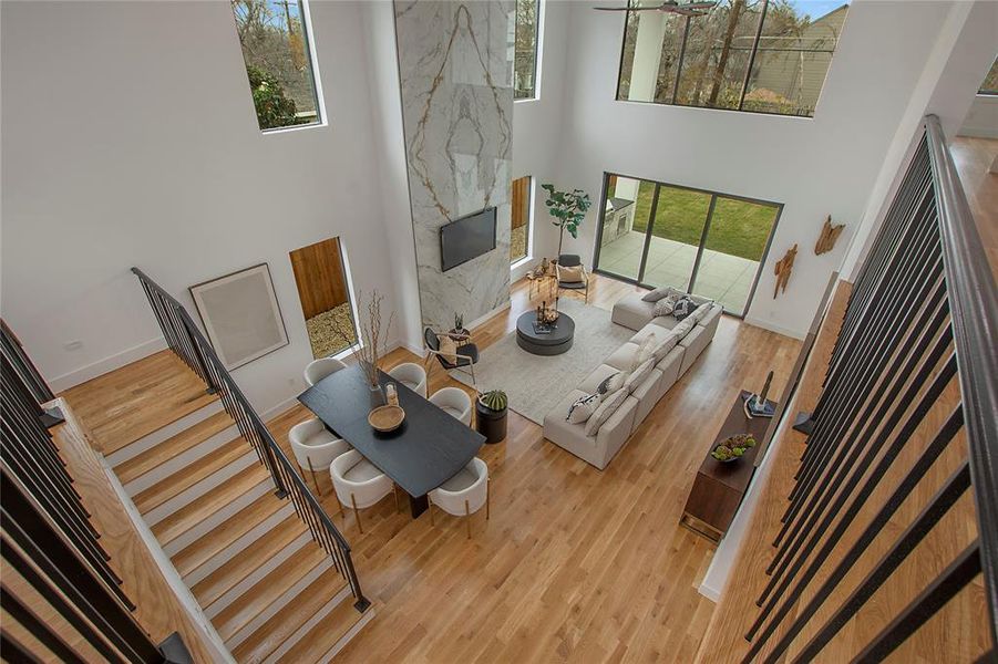 Living room featuring plenty of natural light, a high ceiling, and light wood-type flooring