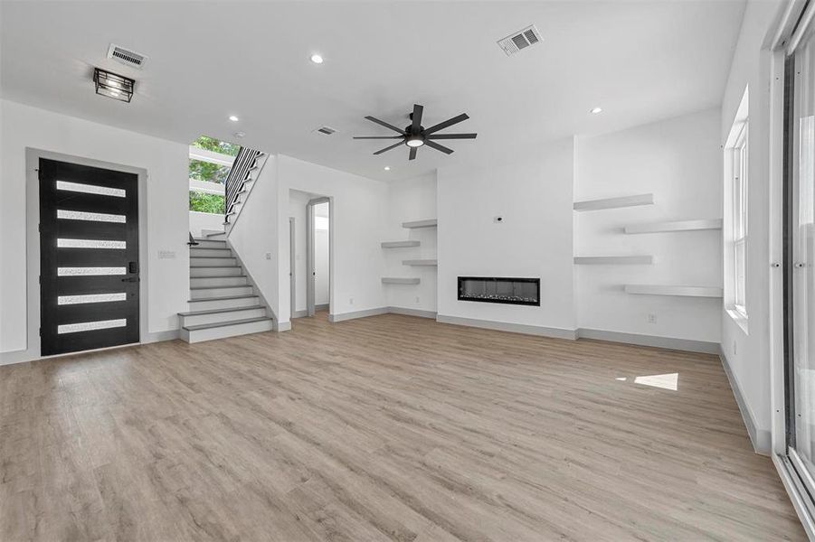 Unfurnished living room featuring ceiling fan and light hardwood / wood-style flooring