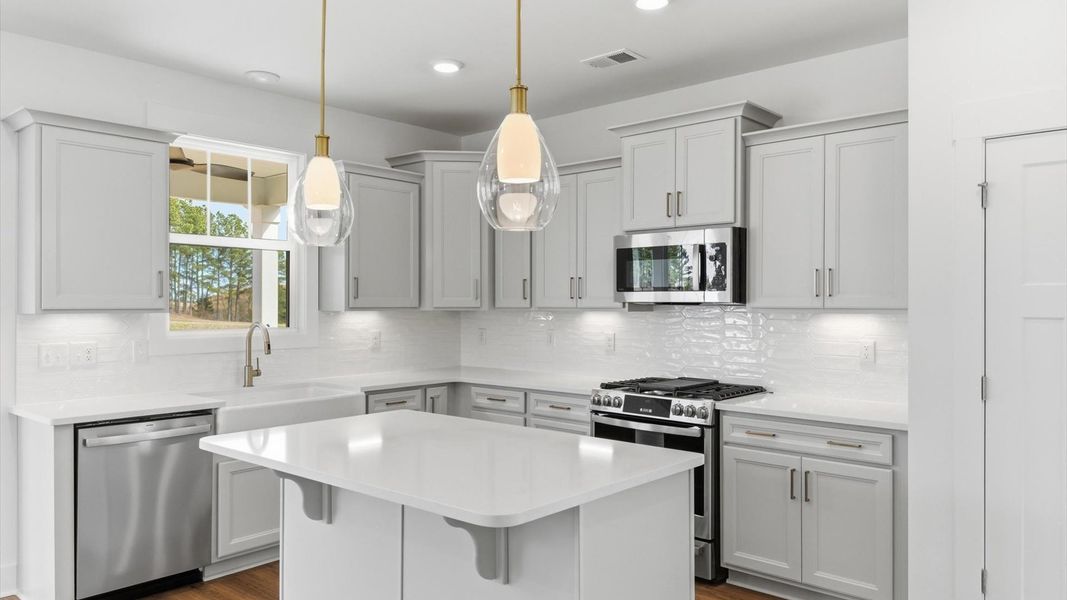 First-rate kitchen with functional layout, designer pendant lighting, and a large center island in this single family home