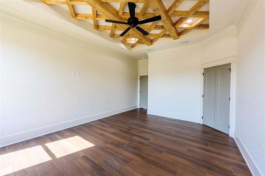 Empty room featuring coffered ceiling, dark wood-style floors, crown molding, a ceiling fan, and recessed lighting