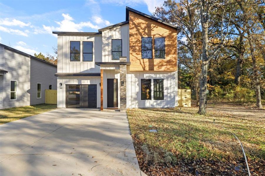 View of front of home with a front yard and a garage