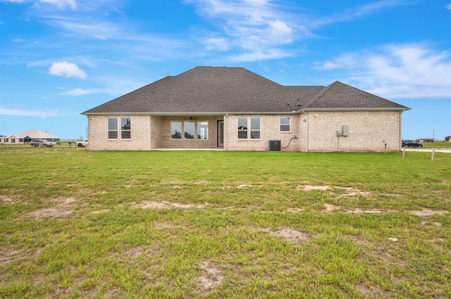 Rear view of house featuring a yard and central AC unit Rear view of house featuring a yard and central AC unit