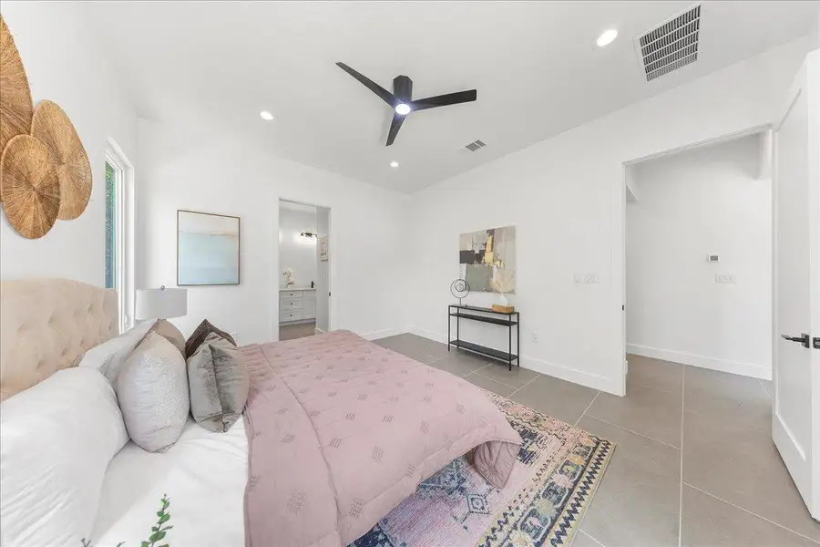 Tiled bedroom with recessed lighting, a ceiling fan, and ensuite bath Tiled bedroom with recessed lighting, a ceiling fan, and ensuite bath