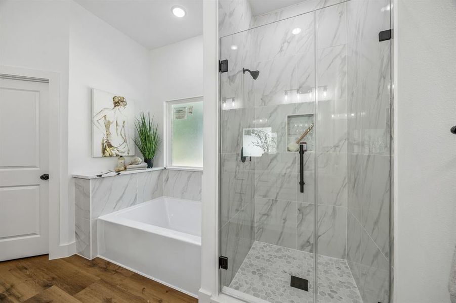 The frameless glass shower and soaking tub are highlights of the ensuite primary bathroom.