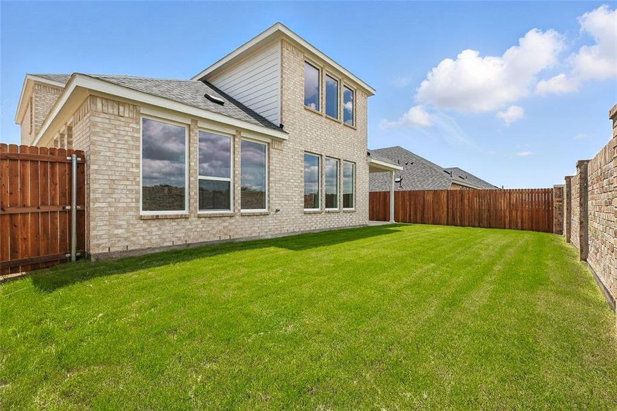 Rear view of property with brick siding, a fenced backyard, and roof with shingles Rear view of property with brick siding, a fenced backyard, and roof with shingles