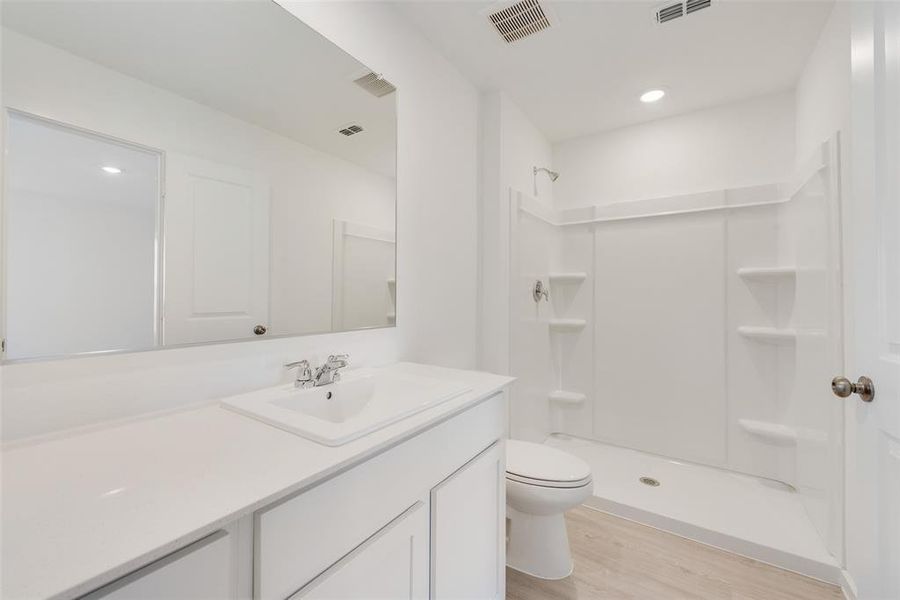 Bathroom with toilet, hardwood / wood-style floors, walk in shower, and vanity