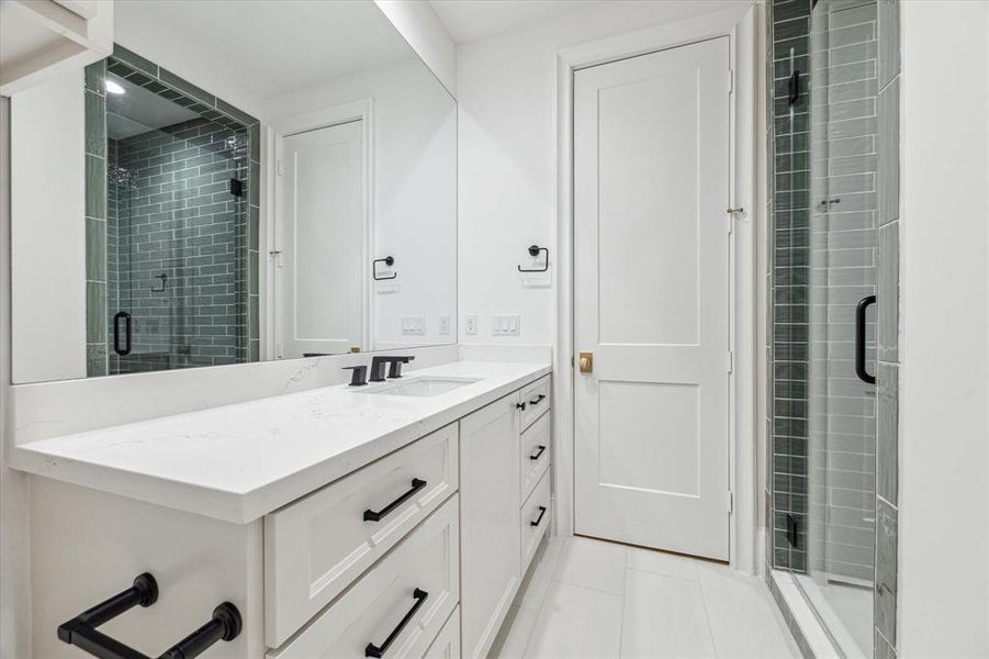 En-suite secondary bathroom. Check out the beautiful green shower tiles in one of the en-suite secondary bathrooms, bringing a pop of color and a touch of feng shui!