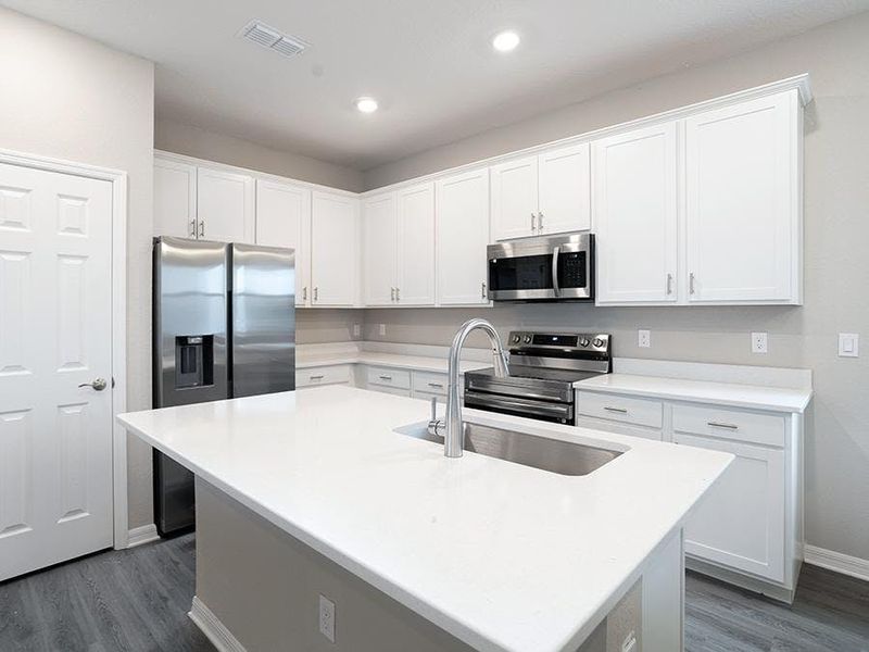 Your sunny kitchen includes an island, pantry, and beautiful finishes - Capri bungalow by Highland Homes