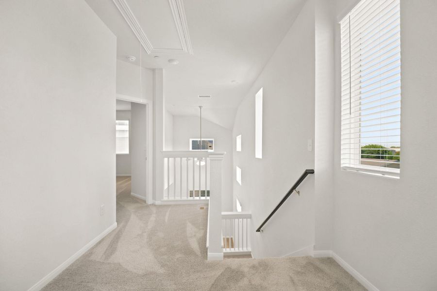 An airy upstairs landing connects the bedrooms with plush carpeting and natural light.