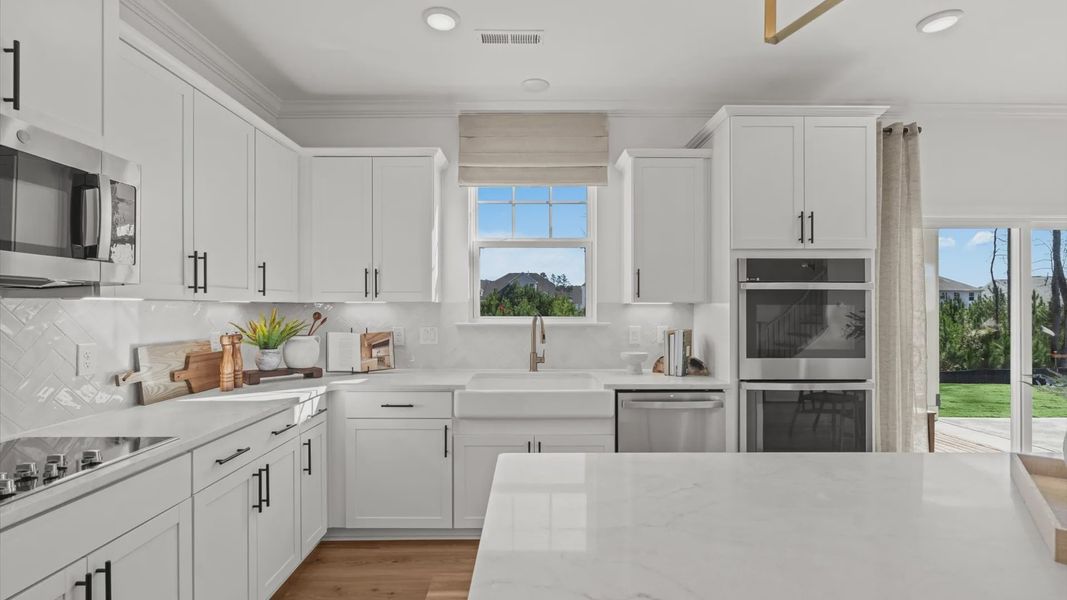 Wynwood home plan statement kitchen with center island, tile backsplash, ample countertop and cabinet space, double ovens Wynwood home plan statement kitchen with center island, tile backsplash, ample countertop and cabinet space, double ovens