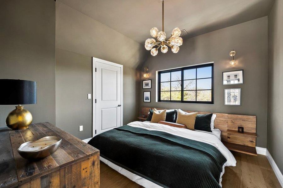 Bedroom featuring suspended lighting, wood finished floors, and lofted ceiling