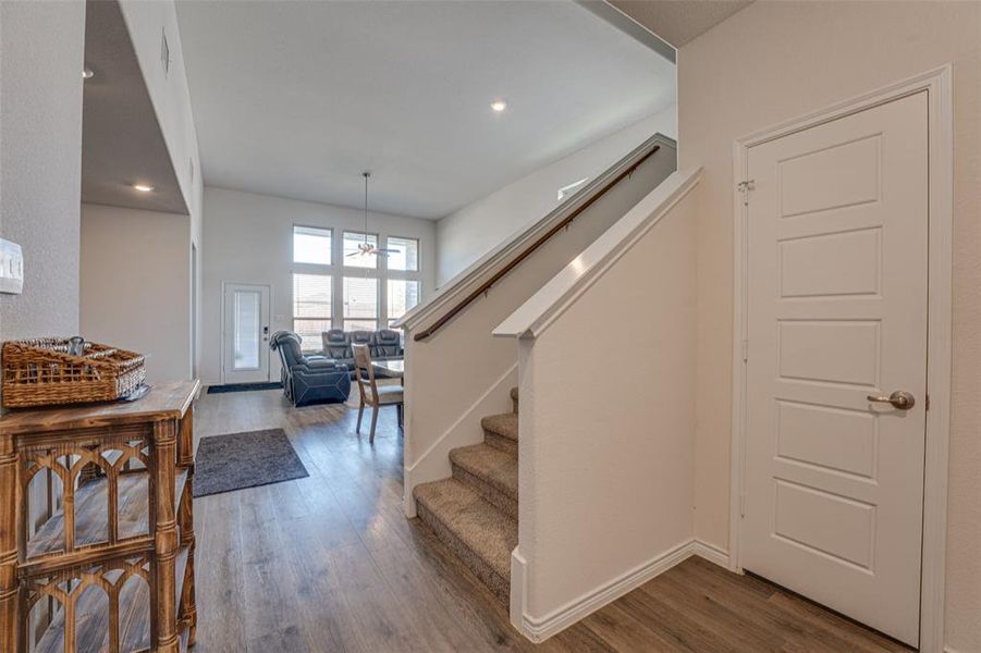 Stairs with wood finished floors and recessed lighting