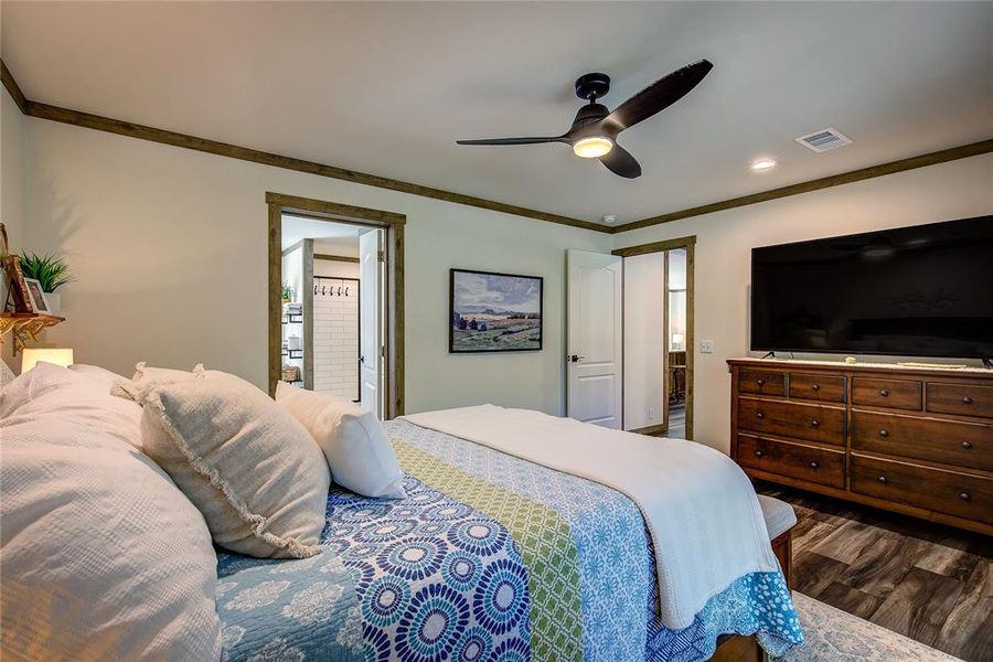 Bedroom featuring  ornamental molding, a ceiling fan, and connected bathroom