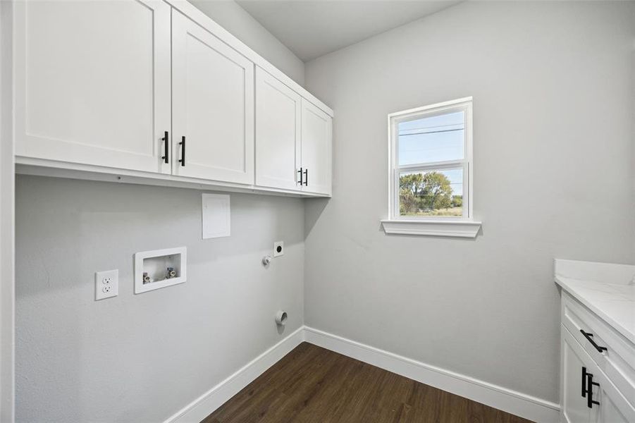 Washroom featuring cabinet space, dark wood-style flooring, hookup for a washing machine, and electric dryer hookup