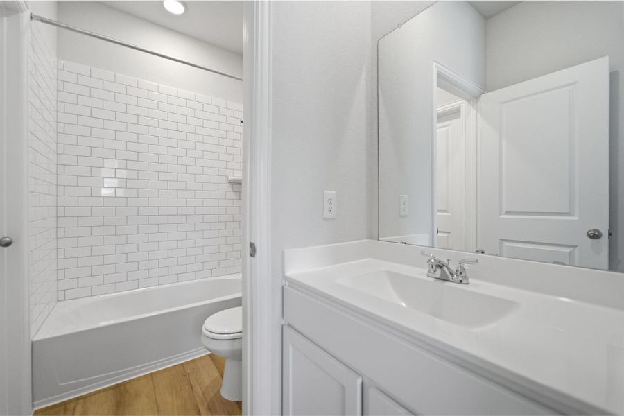 Full bath featuring vanity, light wood finished floors, and shower / washtub combination