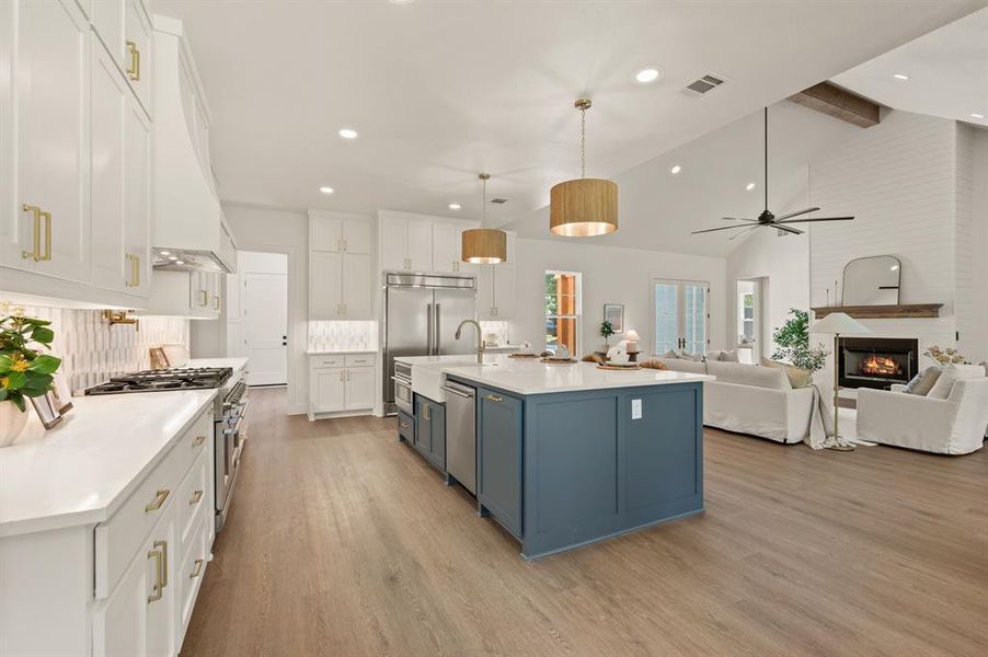 Kitchen with white cabinetry, beam ceiling, light wood-style flooring, ceiling fan, and light countertops Kitchen with white cabinetry, beam ceiling, light wood-style flooring, ceiling fan, and light countertops