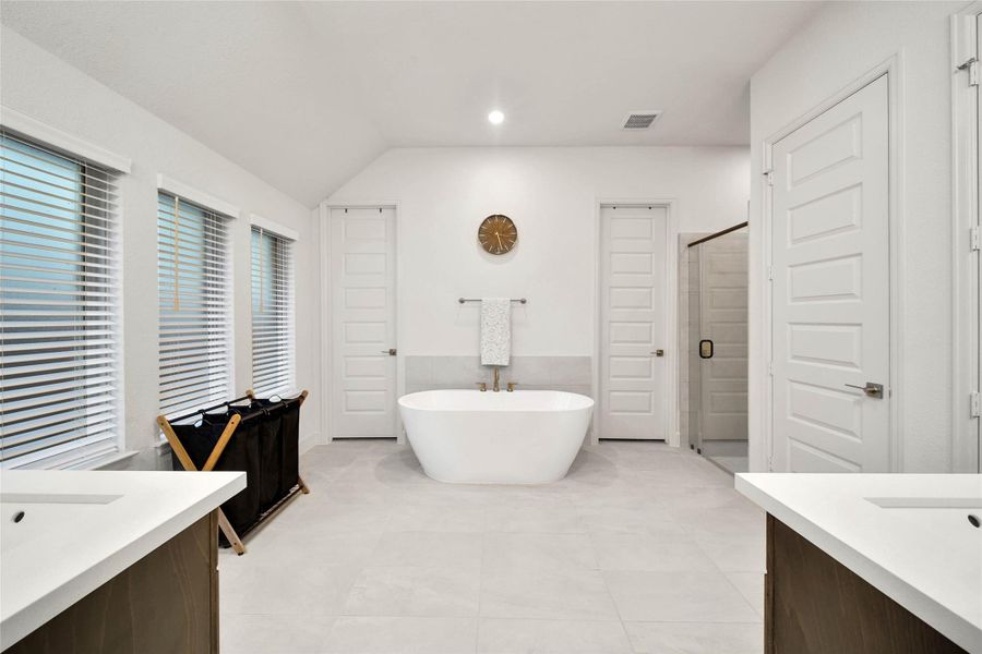 There's room to comfortably move between the spaces here in this well appointed primary bath.