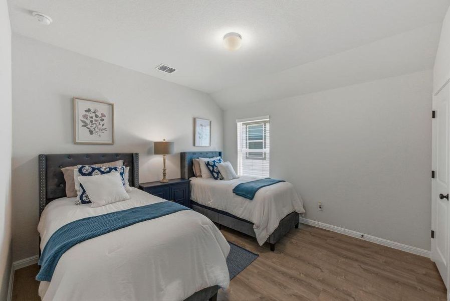 Bedroom featuring lofted ceiling and light wood finished floors