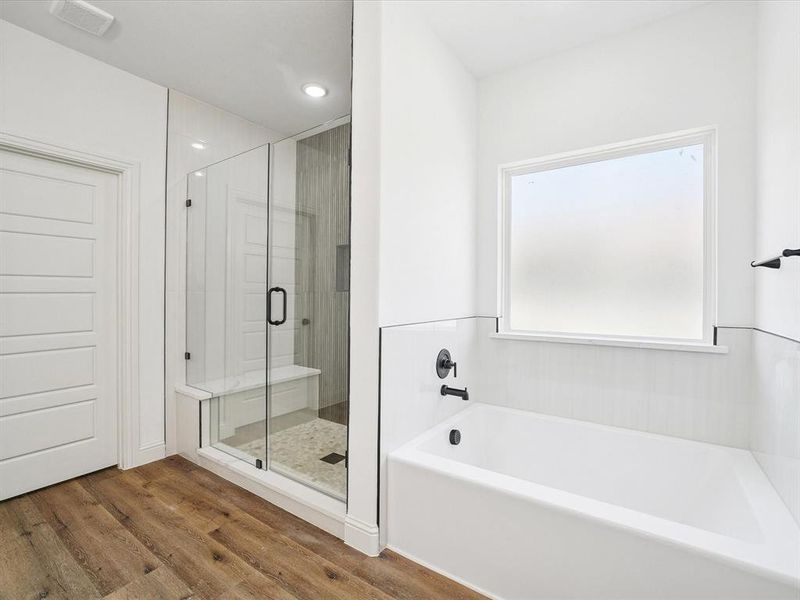 Full bathroom with a stall shower, a bath, wood finished floors, and recessed lighting