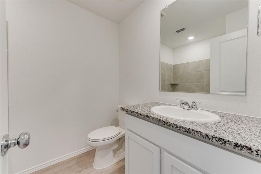 Bathroom featuring vanity, toilet, and hardwood / wood-style flooring