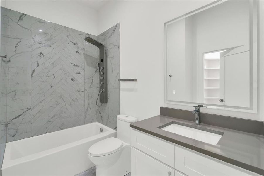 Full bathroom featuring toilet, vanity, and tiled shower / bath