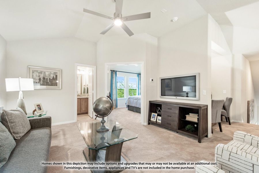 Carpeted living room with vaulted ceiling, ceiling fan, wall-mounted TV, and view into bedroom and bathroom Carpeted living room with vaulted ceiling, ceiling fan, wall-mounted TV, and view into bedroom and bathroom