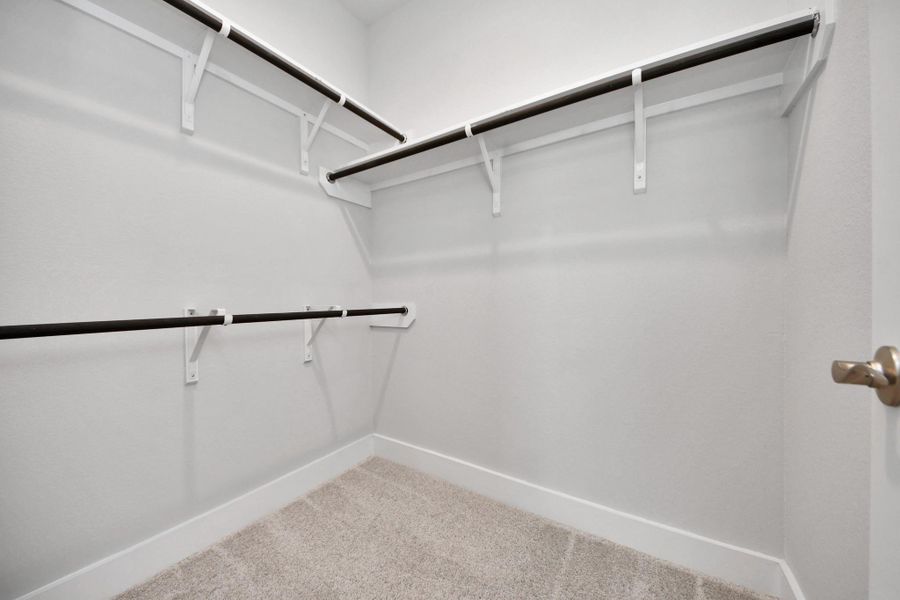 Walk-in closet that epitomizes luxury and practicality. This generously sized space features built-in shelving, offering abundant room for impeccable organization. High ceilings and recessed lighting create a bright and welcoming ambiance.