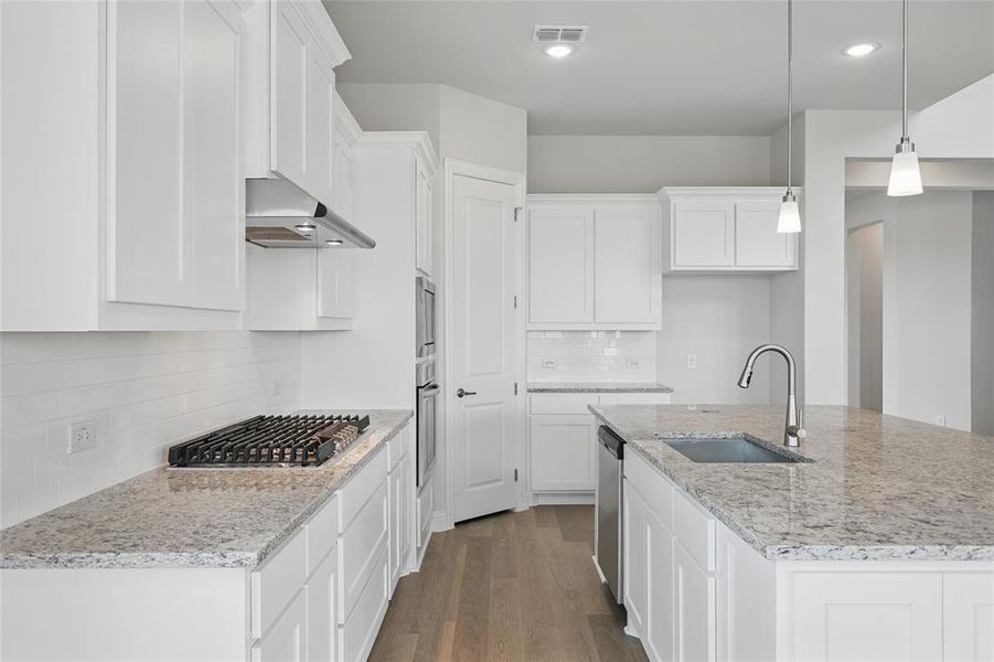 Kitchen with a sink, appliances with stainless steel finishes, white cabinetry, tasteful backsplash, and recessed lighting