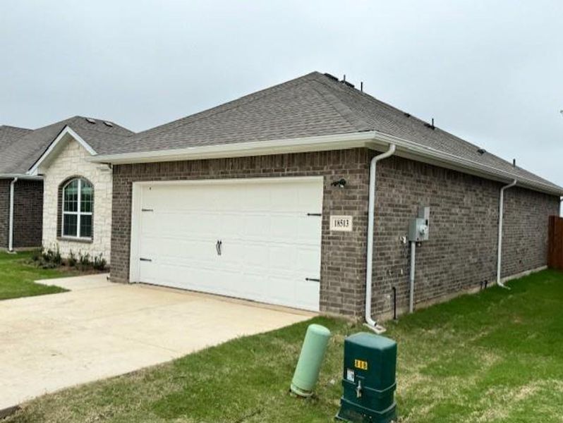 View of property exterior with concrete driveway, an attached garage, a lawn, and roof with shingles View of property exterior with concrete driveway, an attached garage, a lawn, and roof with shingles