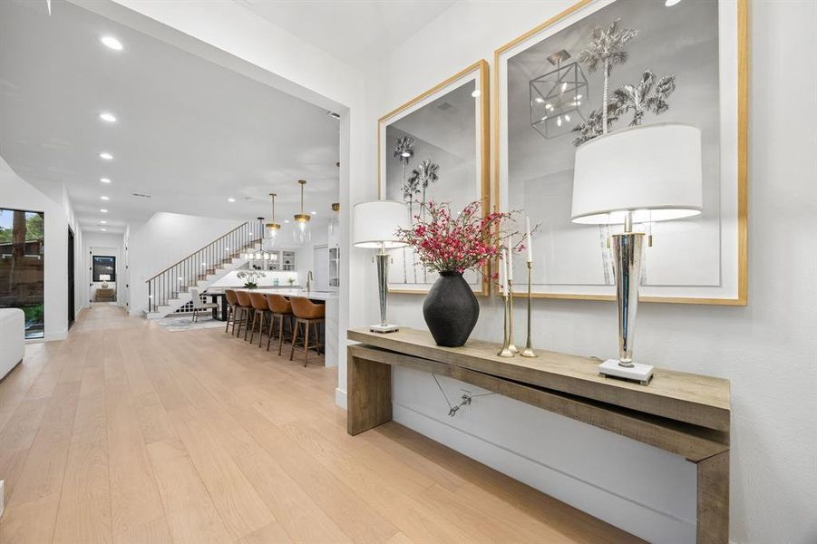 Welcoming entry with designer finishes and warm wood floors, opening to a bright, open-concept living and kitchen area. Welcoming entry with designer finishes and warm wood floors, opening to a bright, open-concept living and kitchen area.