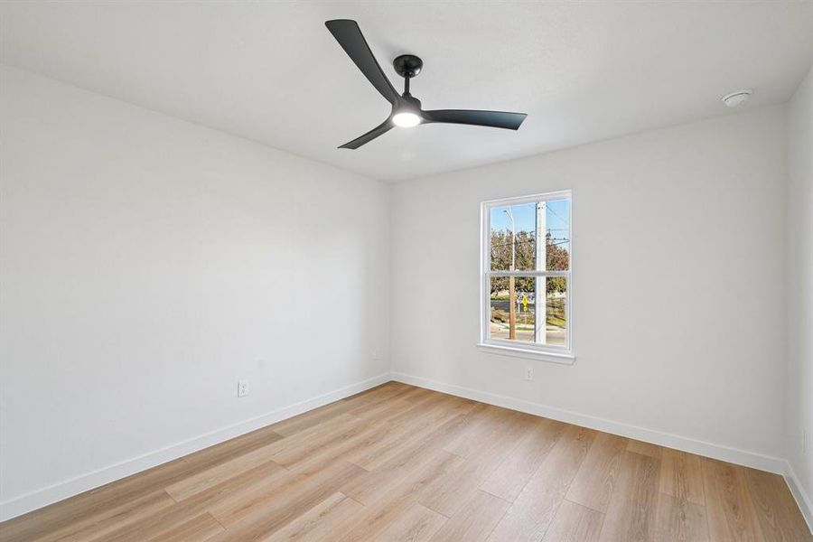 Unfurnished room with light wood finished floors and a ceiling fan