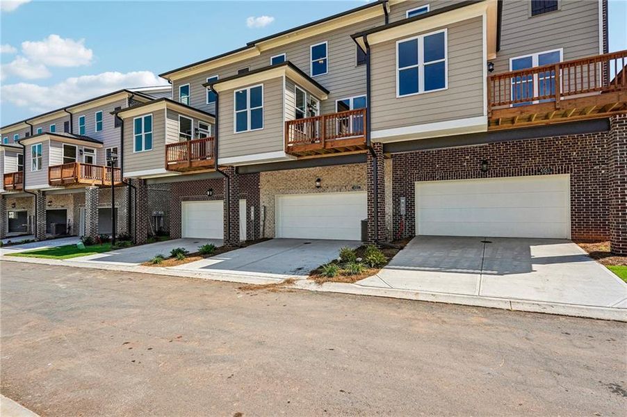 Front exterior of a new home in Waterside Townhomes, Peachtree Corners, GA, highlighting curb appeal (Image 22). Front exterior of a new home in Waterside Townhomes, Peachtree Corners, GA, highlighting curb appeal (Image 22).