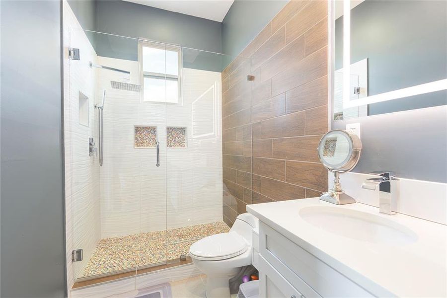 Bathroom featuring a shower stall and vanity Bathroom featuring a shower stall and vanity