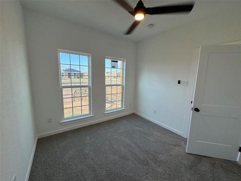 Room 2 featuring dark colored carpet and ceiling fan