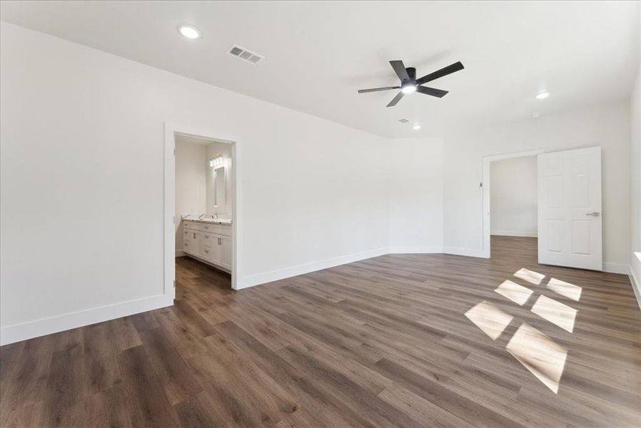 Primary Bedroom, wood-style vinyl floors, and ceiling fan