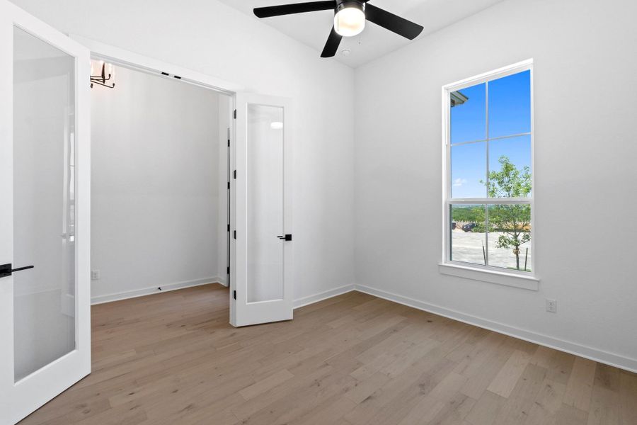 Spare room with light wood finished floors and ceiling fan