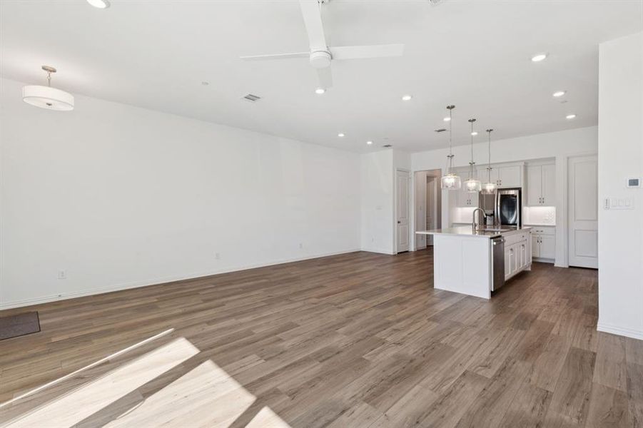 Unfurnished living room with variated wood-type flooring, recessed lighting, and a ceiling fan Unfurnished living room with variated wood-type flooring, recessed lighting, and a ceiling fan